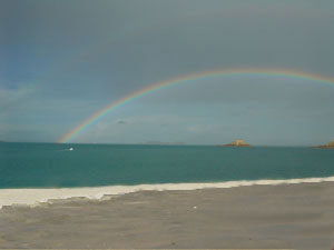 Coastal rainbow with blue sky